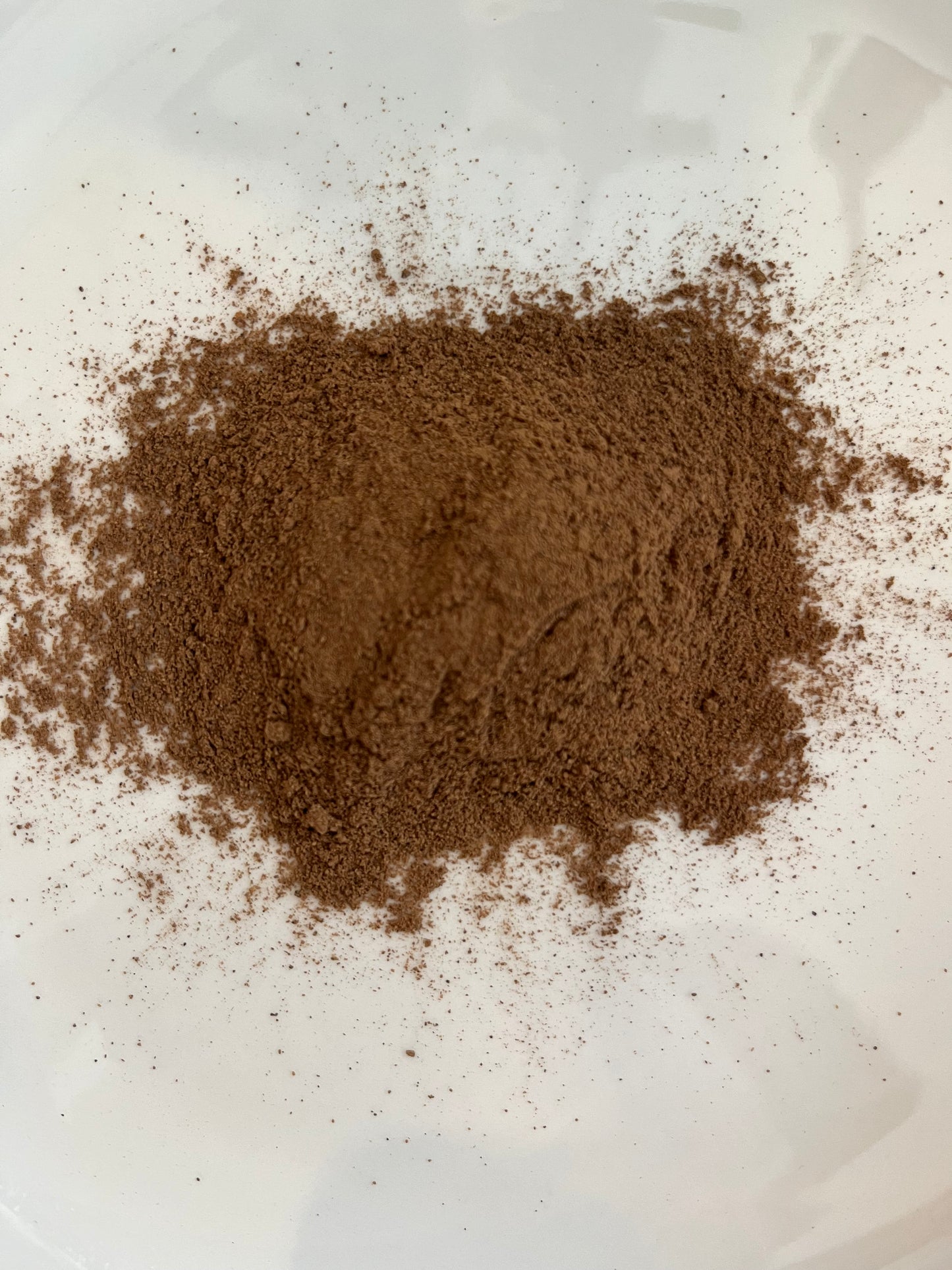 Loose dried ground Allspice in a white bowl