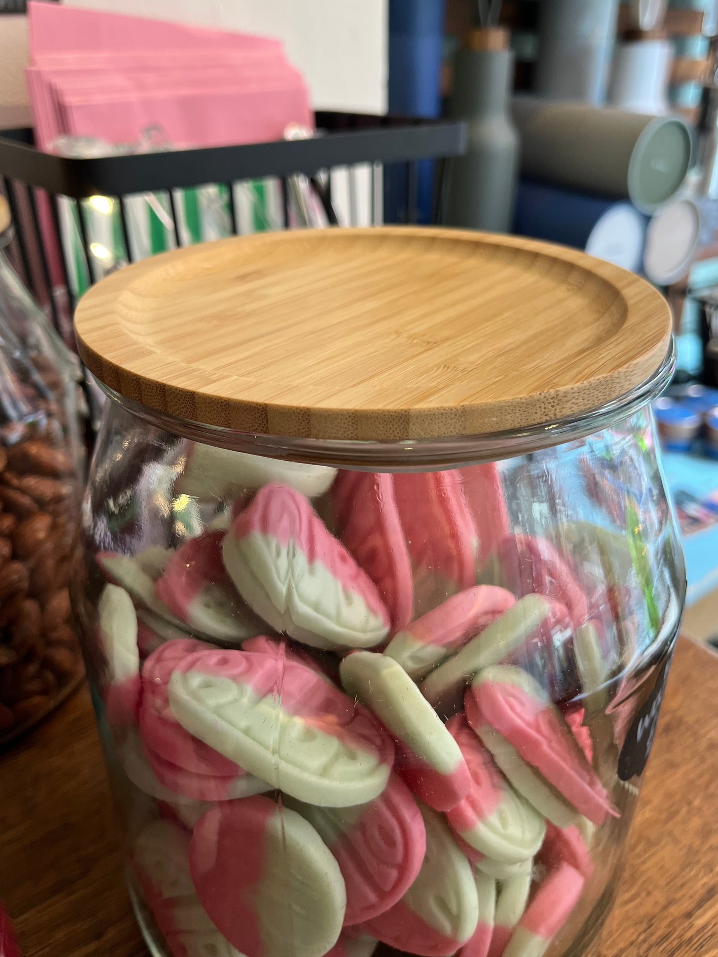 A big jar filled with pink and green oval foam sweets.