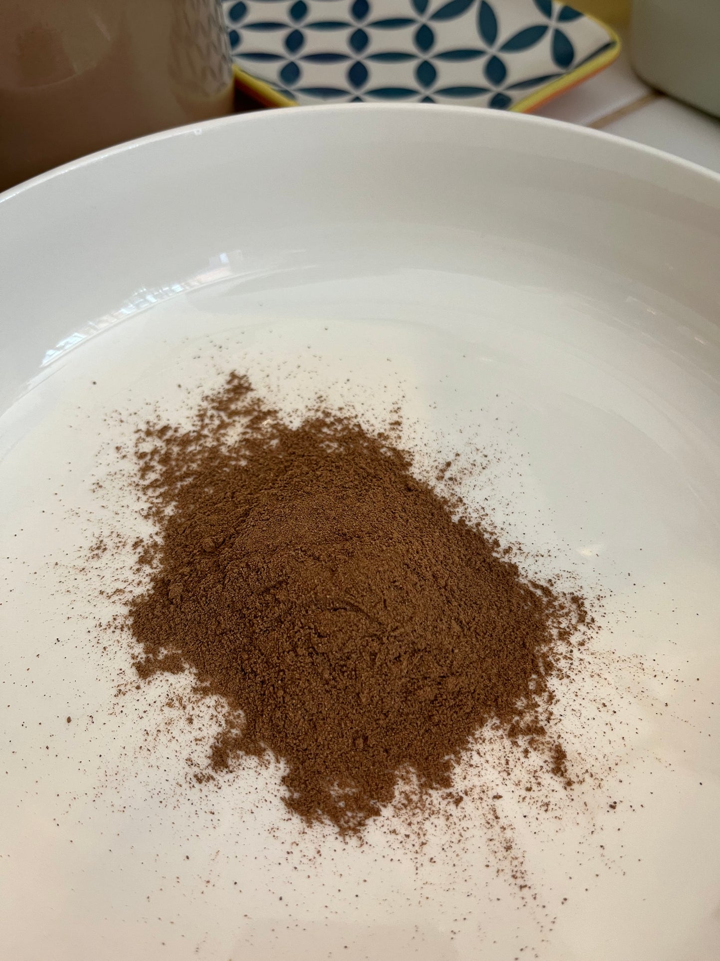 Loose dried ground Allspice in a white bowl