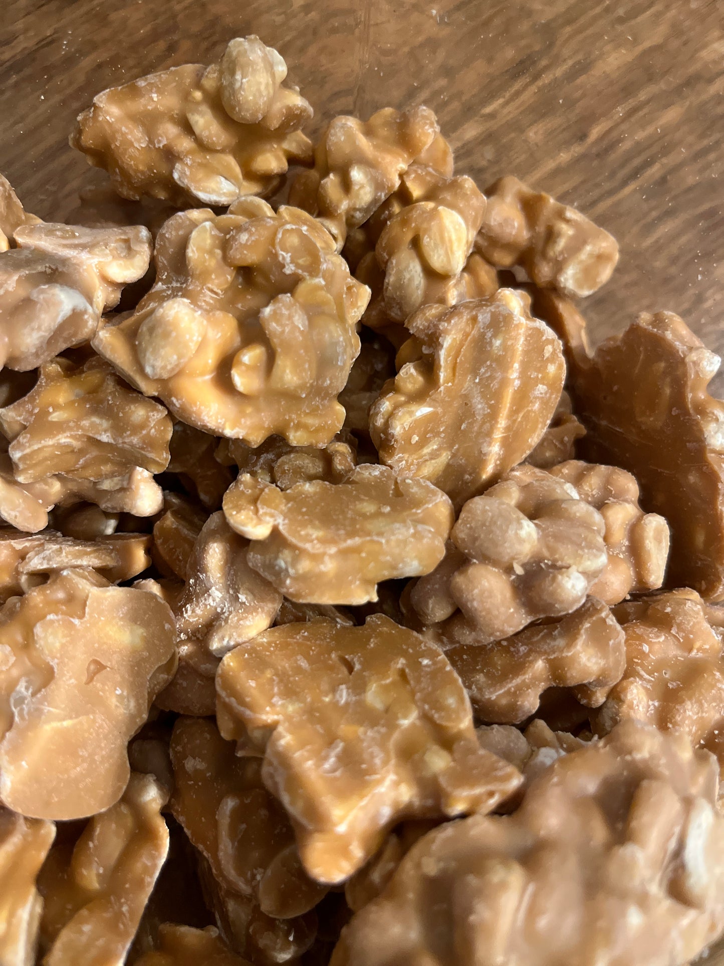 A close up view of pale golden brown clusters of caramel chocolate coated peanuts.