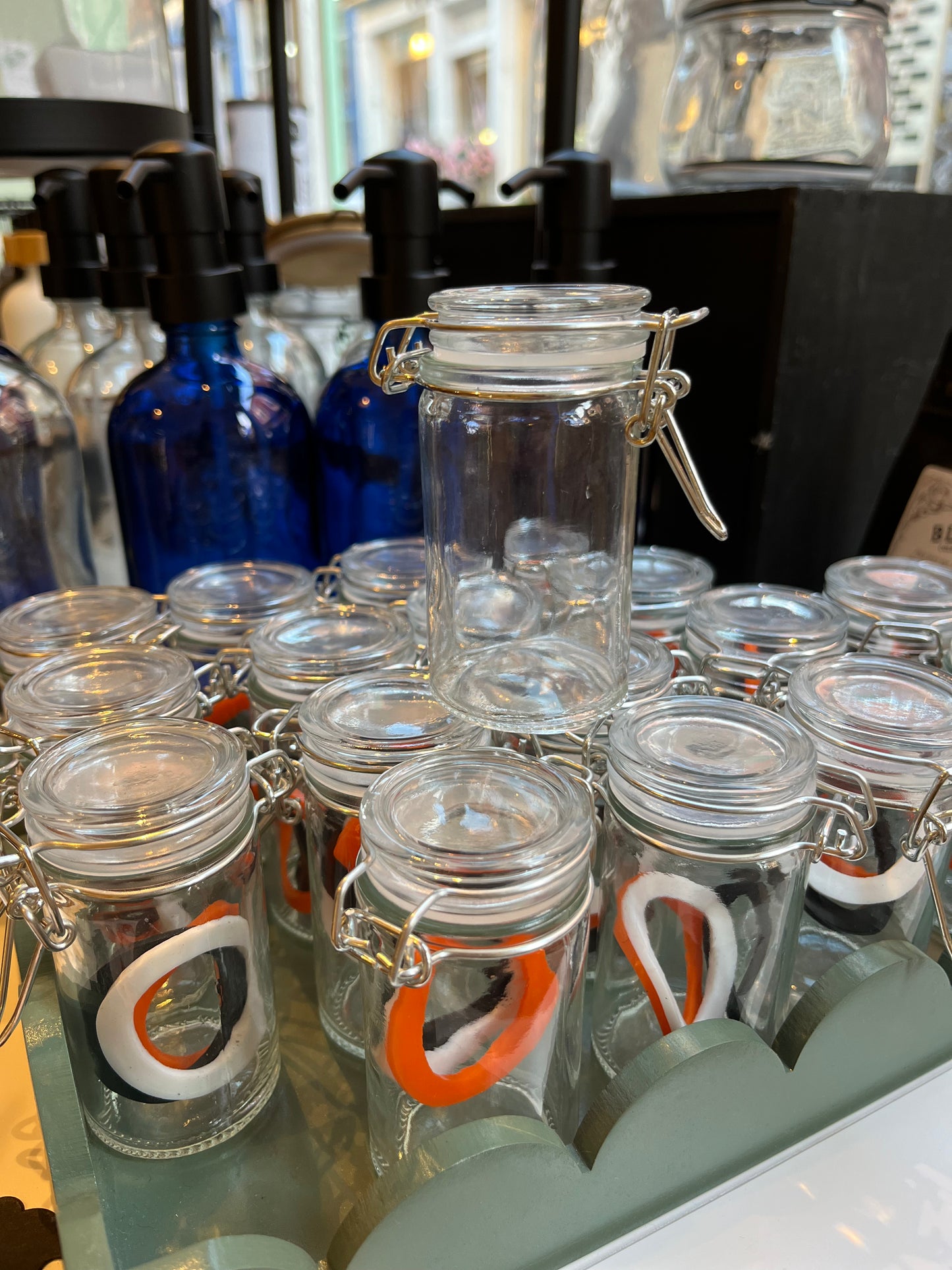 A tray of clear glass kilner-style spice jars with various coloured lid seals.