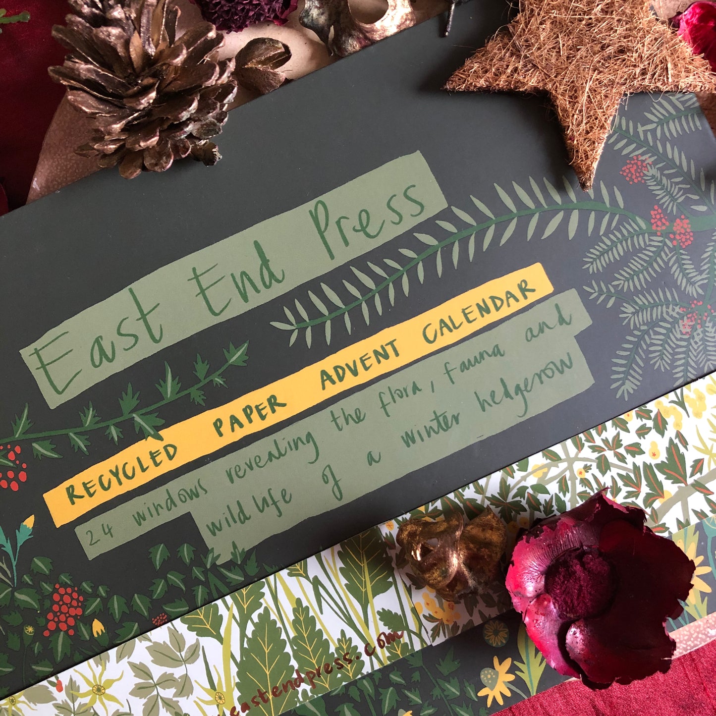 A close up of the back of the advent calendar, reading;
‘East End Press
Recycled Paper Advent Calendar
24 windows revealing the flora, fauna and wildlife of a winter hedgerow’